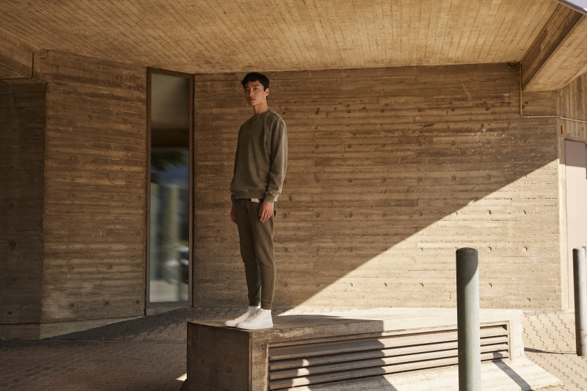 A man standing straight in a room made of wood