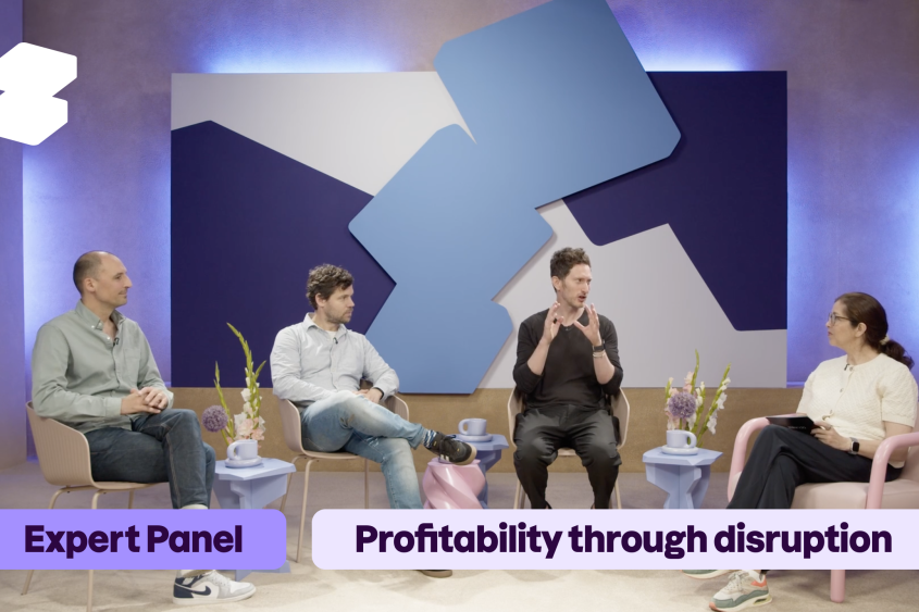 Four people during a panel discussion; Zeos Logo