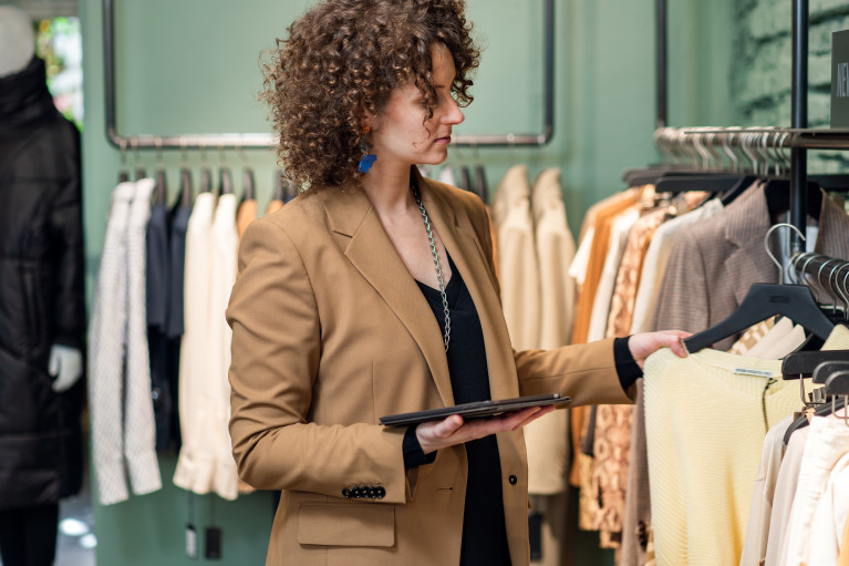 A woman looks at clothes in a shop