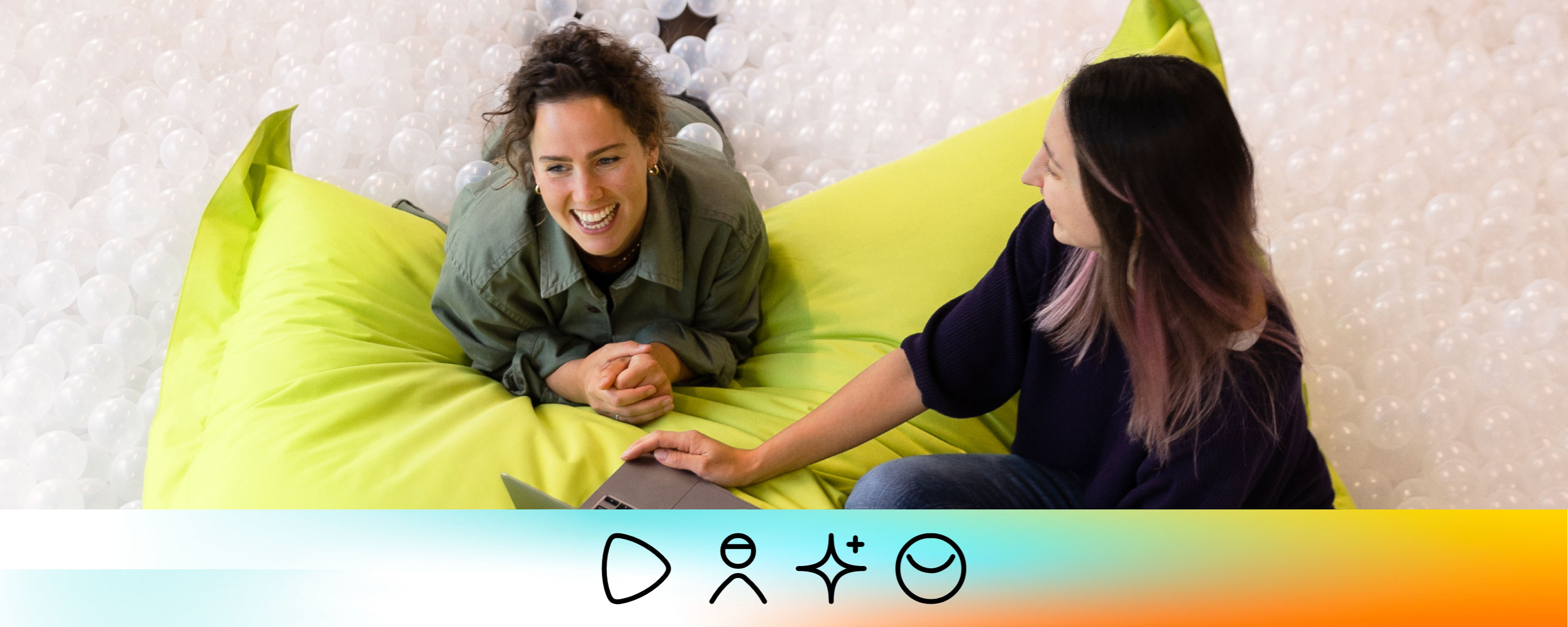 Zalando SE D&I Report 2022 strategy pillar Customer Two Zalando employees working together, sitting on a big pillow in a ball pool