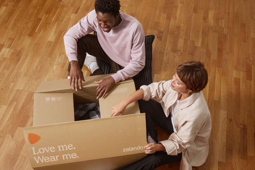 Zalando SE customers A man and a woman open a big Zalando box together.