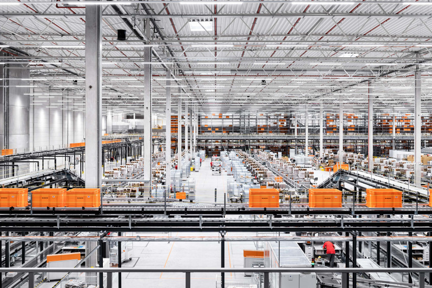 Zalando SE Fulfillment center View into a Zalando fulfillment center. A large hall with workstations and numerous conveyor belts with big orange boxes