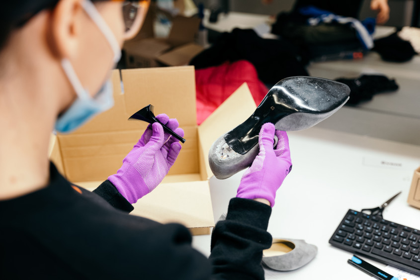 worker with pink protective gloves repairing highheels