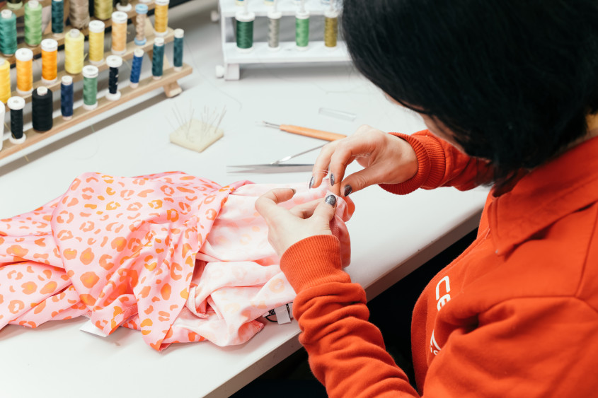 A seamstress doing repairs on a garment.